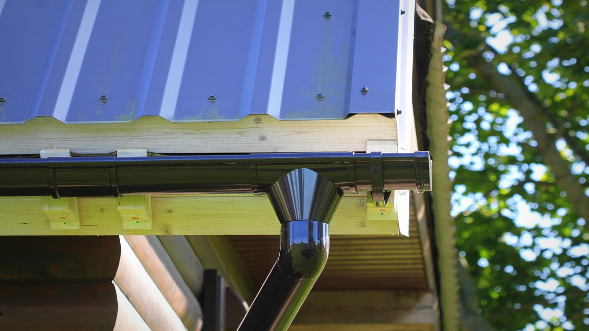 Modern gutter on metal roof shows key parts—ideal for exploring 10 Components of an Effective Gutter System by Conifer Gutter Services.