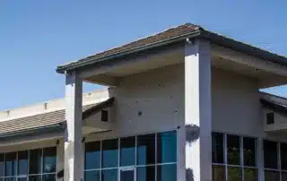 Conifer Gutter Services: Building with unfinished exterior walls and windows, awaiting gutter installation for complete protection and water drainage.