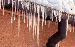 Learn the difference between ice dams and icicles and what they reveal about your gutters. Icicles hanging from a snowy rooftop gutter can signal heat loss or poor drainage, while ice dams may lead to leaks, roof damage, and costly repairs if ignored.