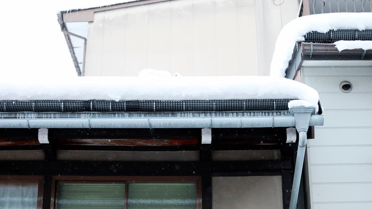 Snow Retention Systems What Denver Builders Are Specifying in 2026 Snow-covered roof with icicles - Snow Retention Systems What Denver Builders Are Specifying in 2026