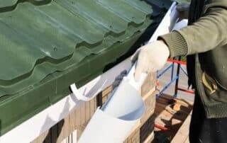 Worker installing a roof gutter system.