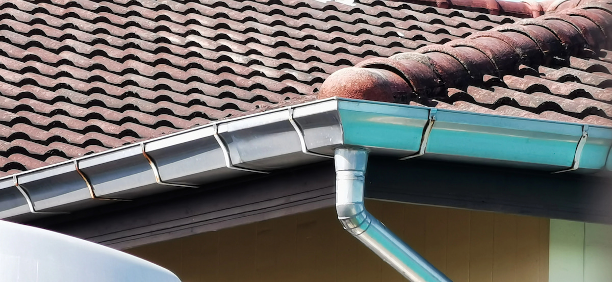 What Gutters Require the Lowest Maintenance House roof with gutter and downspout system